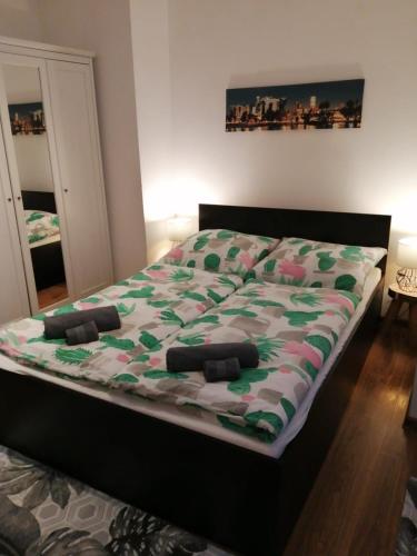 a bedroom with a bed with a green and pink quilt at Przy rynku in Duszniki Zdrój