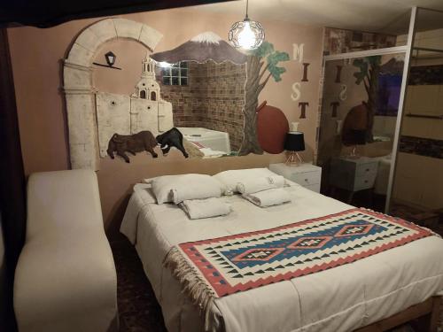 アレキパにあるSillary Hostal Boutiqueの壁に絵が飾られたベッドのある寝室