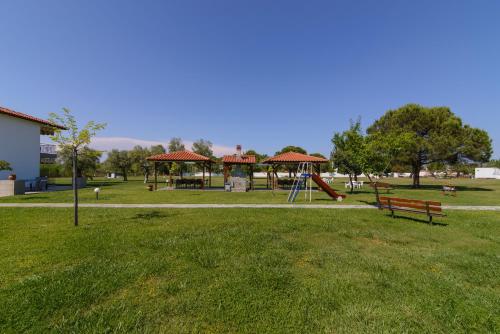 a park with a playground with a slide and a bench at Studios Anna in Vourvourou