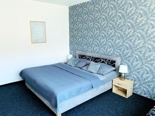 una camera con letto blu a parete di Apartmány na Zahradní a Břeclav