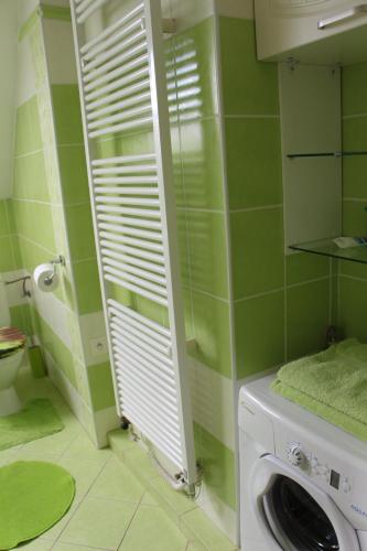 una lavatrice in un bagno con piastrelle verdi di Vila Emilie - Hradební 44, Nové Hrady a Nové Hrady