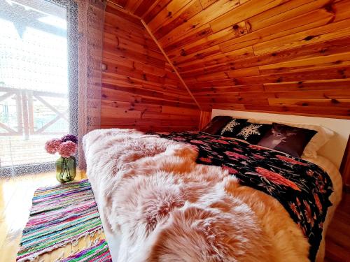 a bed in a room with a wooden ceiling at Siedlisko na Wzgórzu - Noclegi Agroturystyka - Borsuki in Sarnaki