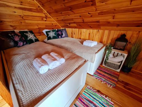 a room with two beds in a wooden cabin at Siedlisko na Wzgórzu - Noclegi Agroturystyka - Borsuki in Sarnaki