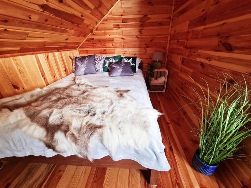 a bedroom with a bed in a wooden room at Siedlisko na Wzgórzu - Noclegi Agroturystyka - Borsuki in Sarnaki