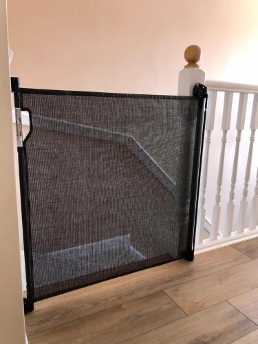 a mesh screen door in a hallway next to a staircase at Corner Cottage - character, charm, great location. in Ringwood