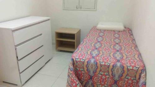 a small bedroom with a bed and a dresser at Casa Logan - Condomínio Village, Casa 15 in Maragogi