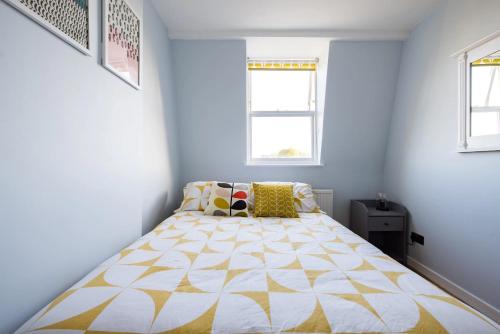 a bedroom with a bed with a yellow and white comforter at Luxurious 1-Bedroom Apartment in Kensington in London