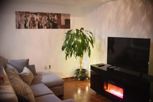 a living room with a couch and a flat screen tv at The House of Cinema in Guanajuato