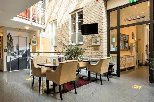 un restaurante con mesa, sillas y TV en Hotel Concordia, en Lund