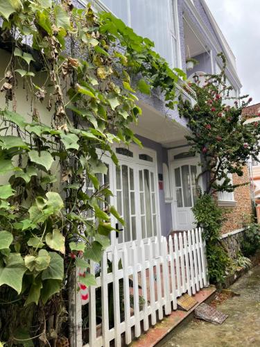 a white picket fence in front of a house with a white gate at Evangeline House in Da Lat