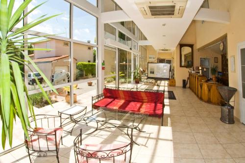 une chambre avec un canapé et des chaises dans un bâtiment dans l'établissement Logis Hôtel restaurant Les Minotiers, à Mirepoix