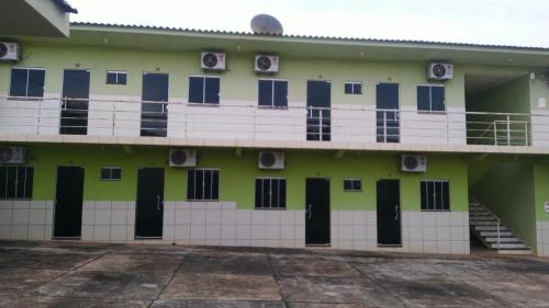 a building with a lot of doors and a balcony at Hotel Kolosso in Aragarças