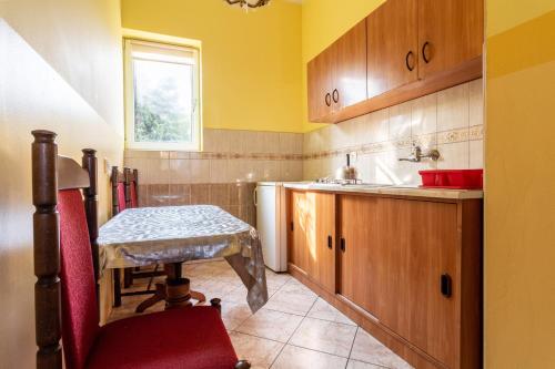 uma pequena cozinha com uma mesa e um lavatório em OW Wilk - pokoje i domki z aneksami kuchennymi, parking, plac zabaw em Łeba
