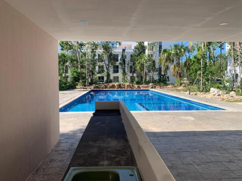 a swimming pool in the middle of a building at Departamento 2 habitaciones con vista a la piscina by EITA in Cancún