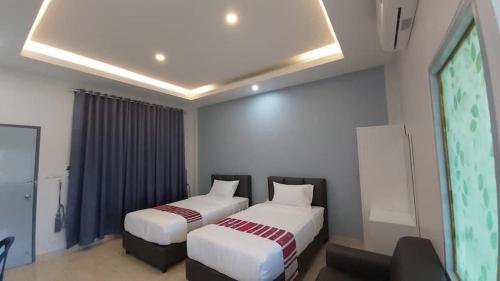 a bedroom with two beds and a projection screen at New blessing Home นิวเบลสซิ่ง โฮม in Nan