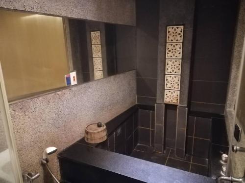 a bathroom with a black sink and a mirror at Shan-Yue Hotspring Hotel in Taipei