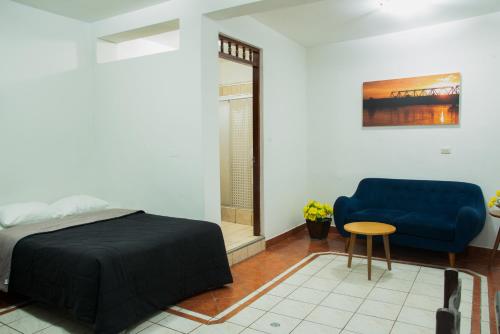 a bedroom with a blue bed and a blue couch at Hospedaje Gran Imperial in Tumbes
