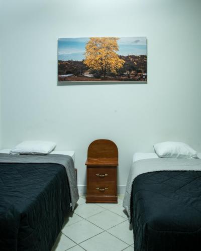 a room with two beds and a picture on the wall at Hospedaje Gran Imperial in Tumbes