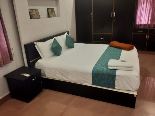 MarudhamalaiSremethila Homestay的卧室里有一张大床，配有蓝色枕头