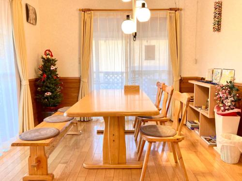 a wooden table and chairs in a room with a christmas tree at Villa Relax in Fujikawaguchiko