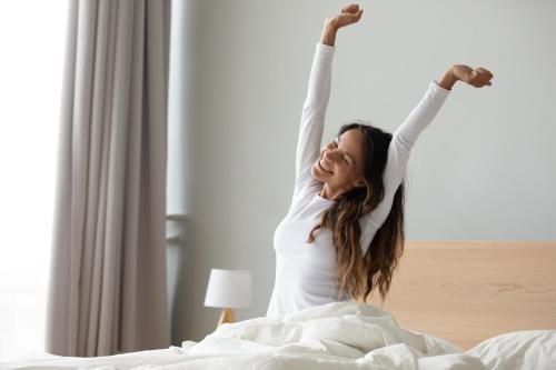 a woman laying in bed with her arms in the air at Ditlin in Pápa