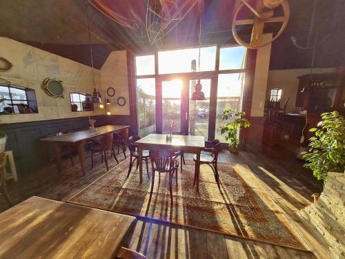 a restaurant with wooden tables and chairs in a room at Verblijf bij Bynt in Sneek