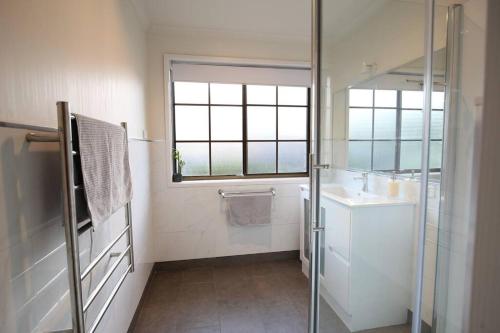 a bathroom with a shower and a sink and a mirror at Bridgecroft Cottage - Cosy 2 bedroom cottage in Richmond