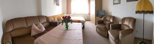 ein Wohnzimmer mit Sofas und einem Tisch mit Blumen darauf in der Unterkunft Wohnung in Mellenthin in Mellenthin