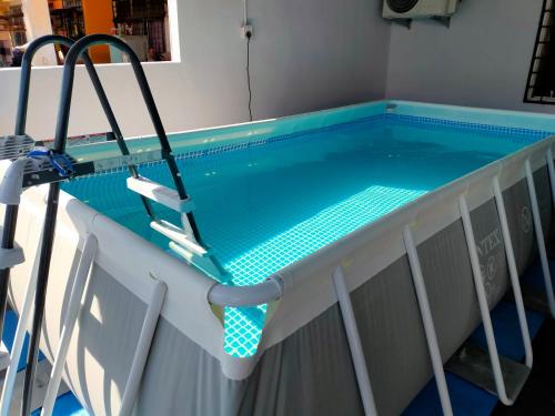 a swimming pool with a diving board in it at Kak Zai Homestay Port Dickson With Private Pool in Port Dickson
