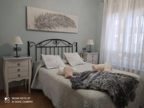 a bedroom with a bed and two nightstands and a bed with a blanket at Gonzalo de Berceo 15 " CALIDAD-SOBRIO" AND " FREE PRIVATE PARKING " in Logroño