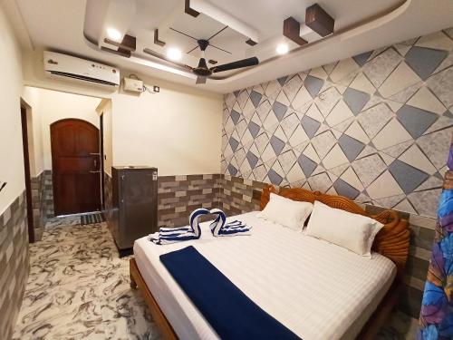 カラングートにあるRichard Inn Residencyのベッドルーム1室(青と白の毛布付きのベッド1台付)