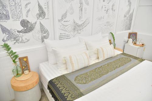 a bedroom with a bed with white sheets and pillows at Silsopa Hostel in Nong Khai