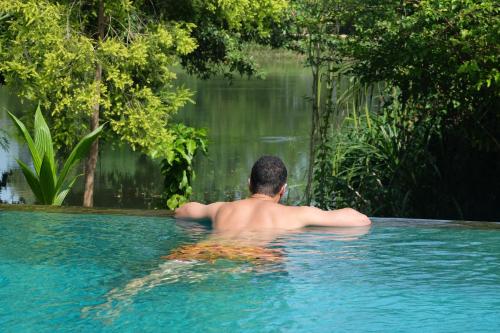 a man in a swimming pool looking at the water at Vimanra Udawalawa in Udawalawe