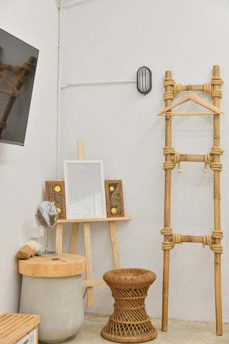 a room with wooden furniture and a stool and a shelf at Silsopa Hostel in Nong Khai