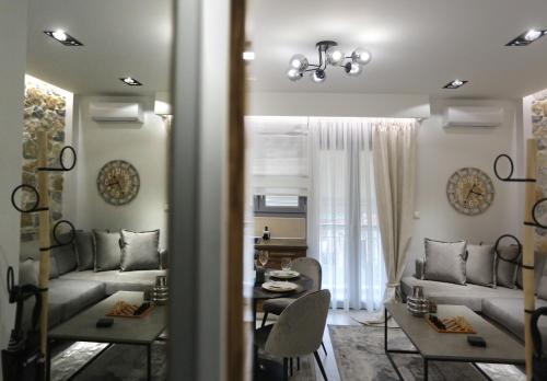 LA Larissa Luxury Apartments Trekke في لاريسا: غرفة معيشة مع أريكة وطاولة