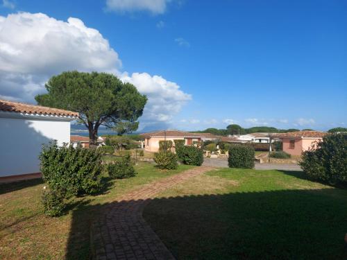 a garden with a brick walkway and a tree at Gallura Dream villas in Budoni