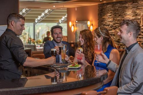 a group of people sitting around a bar with drinks at Banff Park Lodge in Banff