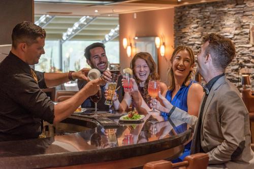 a group of people sitting around a bar drinking wine at Banff Park Lodge in Banff