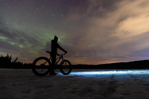 a person standing next to a bike in the snow at Banff Park Lodge in Banff