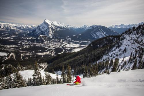 a person is skiing down a snow covered mountain at Banff Park Lodge in Banff