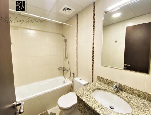 een badkamer met een wastafel, een toilet en een bad bij Spacious one bedroom in Al Jadaf - 5 min to metro in Dubai