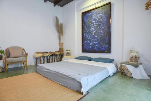 a bedroom with a bed and a large painting on the wall at Silsopa Hostel in Nong Khai