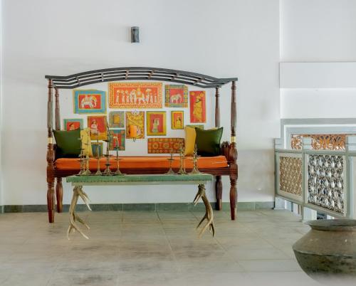 a bench in a room with paintings on the wall at Villa Birdlake in Hikkaduwa