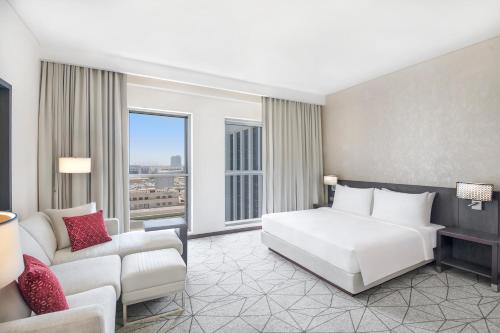 a hotel room with a bed and a couch at Hyatt Place Dubai Jumeirah Residences in Dubai