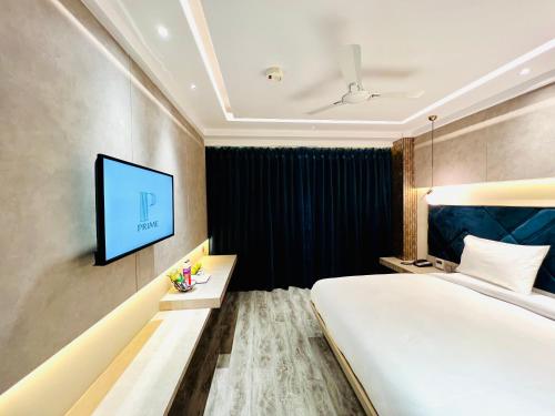 a hotel room with a bed and a flat screen tv at The Prime Delhi in New Delhi