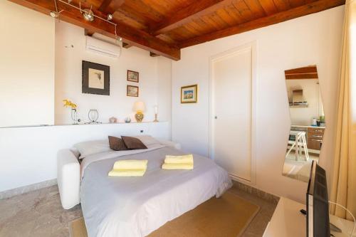 Un dormitorio blanco con una cama y un televisor. en Chalet vista mare a Taormina con parcheggio Paolone House, en Taormina
