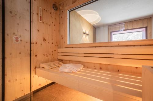 a sauna with wooden walls and a mirror at Biohotel Leutascherhof in Leutasch