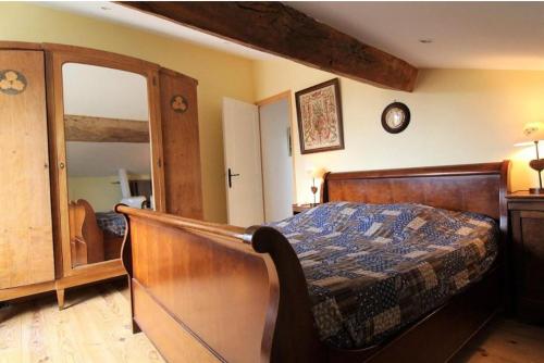 a bedroom with a wooden bed and a mirror at Gite le grenier des maraichers in Albigny-sur-Saone