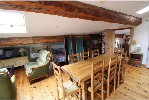 ein Esszimmer mit einem Holztisch und Stühlen in der Unterkunft Gite le grenier des maraichers in Albigny-sur-Saone