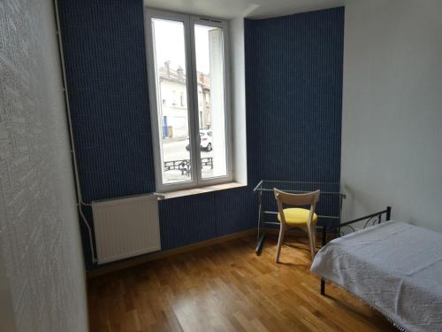 ein Schlafzimmer mit einem Bett und einem Stuhl und einem Fenster in der Unterkunft Appartement Charmant, quartier calme in Nancy